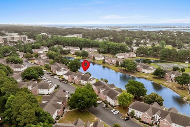 Aerial view of residential area featuring a nearby body of water and a tree filled landscape