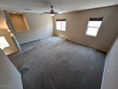 Carpeted empty room with ceiling fan and baseboard