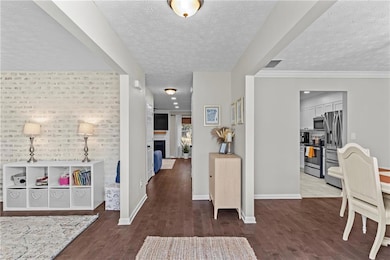 Hallway with dark wood finished floors and a textured ceiling