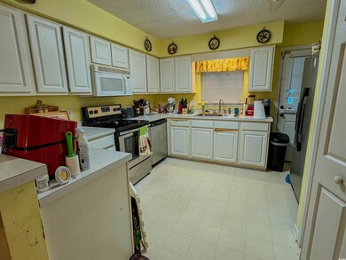 Kitchen with light tile patterned flooring, a text