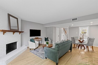 Living area with a fireplace, visible vents, stair