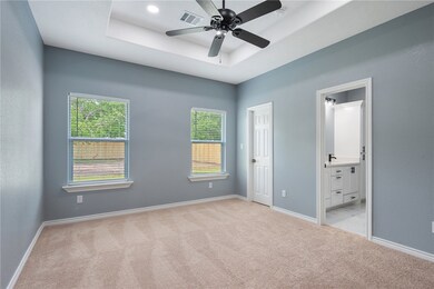 Unfurnished bedroom with a raised ceiling, carpet