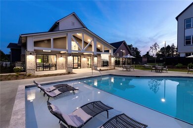 Pool at dusk with a patio and an outdoor bar