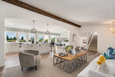 The large windows create breathtaking views in this open concept living room, kitchen combo.