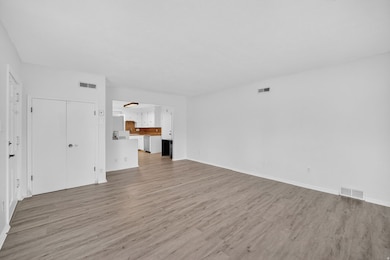 Unfurnished living room with light wood-style floors and baseboards