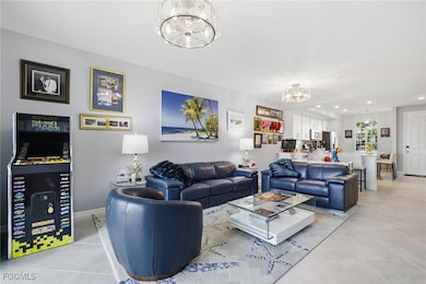 Living area featuring light tile patterned flooring, recessed lighting, and a chandelier