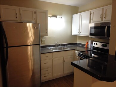 Kitchen with dark countertops, a sink, stainless 