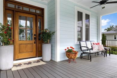View of exterior entry with ceiling fan and covered porch