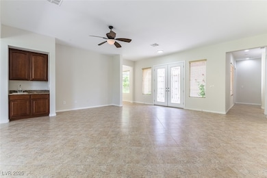 Great Room with ceiling fan, baseboards, a wet bar
