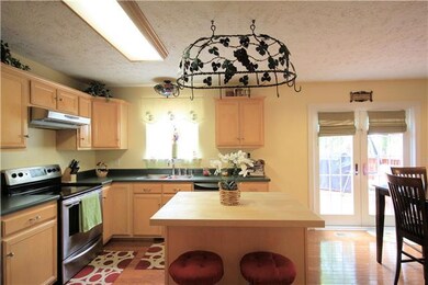 PLENTY OF COUNTER SPACE AND CABINETS INCLUDING AN ISLAND TO HELP PREPARE YOUR MEALS. STAINLESS STEEL REFRIGERATOR TO REMAIN.