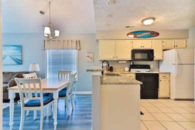 Kitchen with a notable chandelier, white appliance