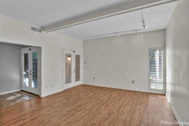 Empty room featuring brick wall, rail lighting, wo