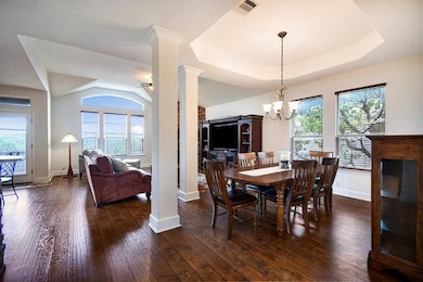 Dining room with a tray ceiling, decorative colum