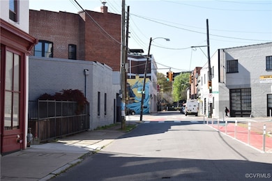 View of road with street lighting, sidewalks, traffic lights, and curbs