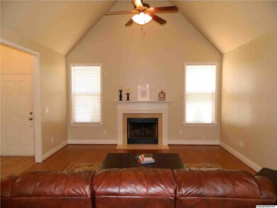 Soaring ceilings highlight this Family Room! There's a wood burning fireplace and gleaming hardwood flooring.