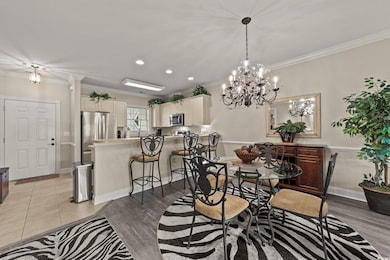 Dining room with crown molding, a chandelier, recessed lighting, baseboards, and light wood finished floors