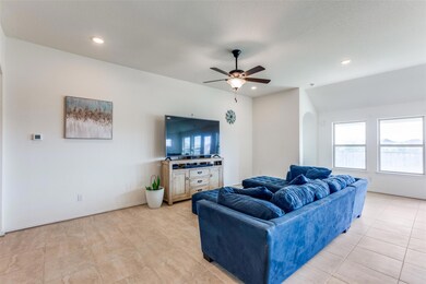 Living room featuring arched walkways, ceiling fan, recessed lighting, and light tile patterned floors