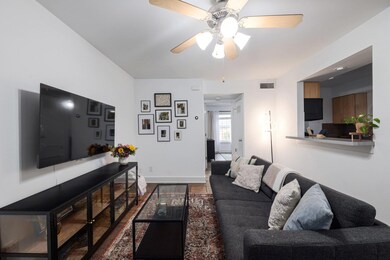 Living room featuring a ceiling fan, dark wood-st
