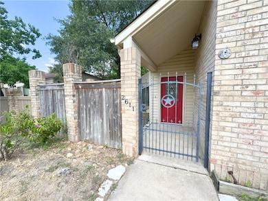 View of exterior entry with a gate and brick siding