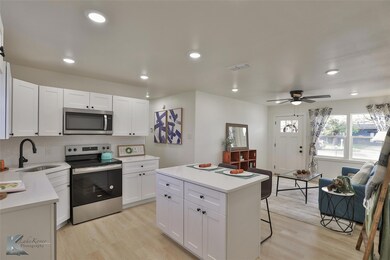 Kitchen featuring white cabinetry, sink, a center 