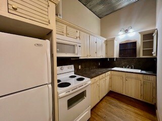 Kitchen with white appliances, wood floors and cre