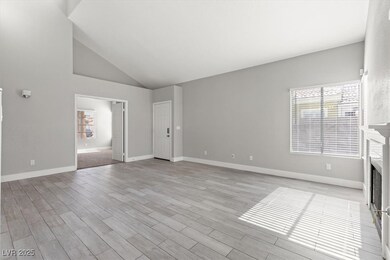 Unfurnished living room featuring a fireplace, light wood-style flooring, and high vaulted ceiling
