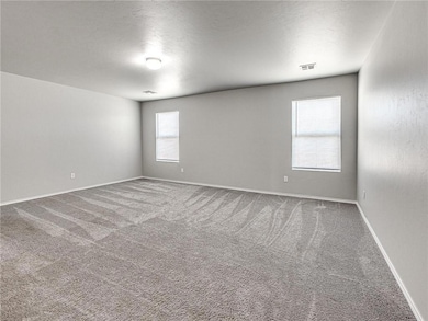 Carpeted spare room featuring baseboards and visib