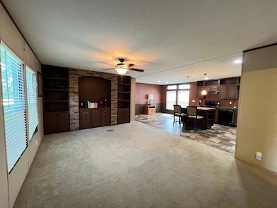 Living room with built in shelves, a ceiling fan,