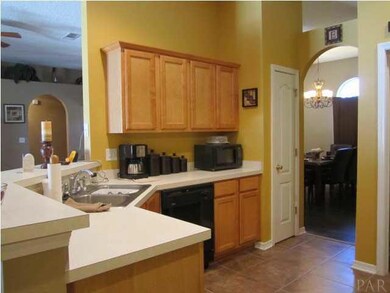 Kitchen - Fully equipped with stainless and black appliances, tile flooring, pantry, breakfast bar, and wood cabinetry