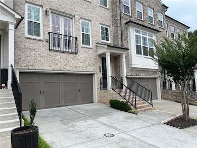 View of front of house featuring a garage, driveway, and brick siding