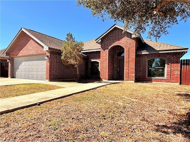 Single story home featuring a shingled roof, brick siding, and concrete driveway