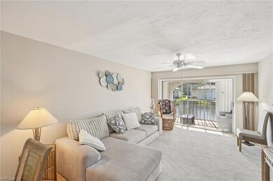 Living room with carpet, a ceiling fan, and a textured ceiling