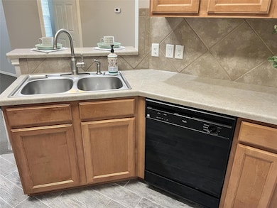 Kitchen with a sink, a peninsula, black dishwashe