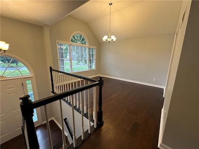Entryway with a chandelier, dark wood finished flo