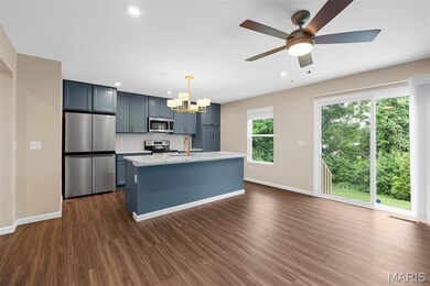 Kitchen featuring appliances with stainless steel finishes, a chandelier, a sink, decorative backsplash, and light countertops
