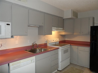 This kitchen features gray cabinetry with ample st