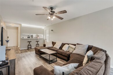 Living room featuring baseboards, a ceiling fan, a