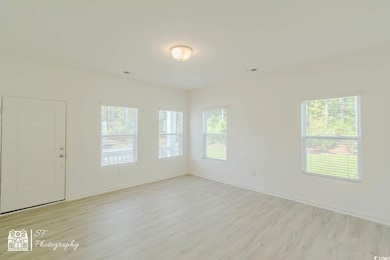 Empty room with light wood finished floors and baseboards