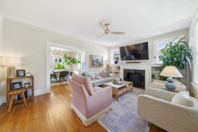 Bright and inviting living room with hardwood floors. Open layout connects to a dining area with lots of natural light. Perfect for comfortable living and entertaining.