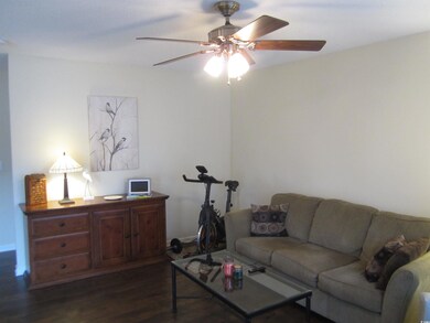 Living room with ceiling fan and dark hardwood / w