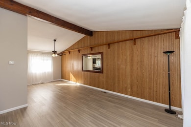 Unfurnished room featuring light wood-style flooring and wood walls