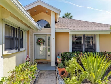 Property entrance featuring roof with shingles and stucco siding