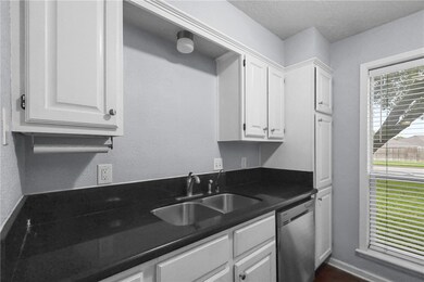 Kitchen with stainless steel dishwasher, white cab