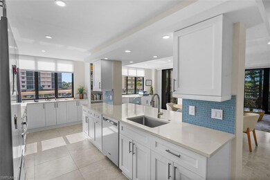 Kitchen with tasteful backsplash, white cabinetry, light stone countertops, recessed lighting, and appliances with stainless steel finishes