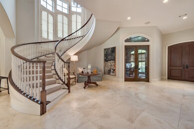 [FOYER]
In the light-filled foyer, the sweeping staircase ascends to the second floor. French doors at rear of photo grant access into the study/library.