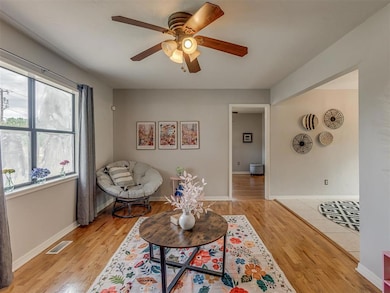 Living area featuring original wood floors and a ceiling fan