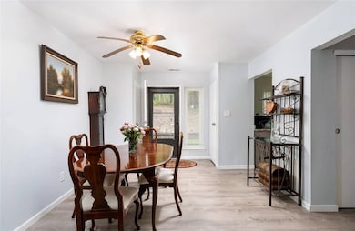 Dining space featuring a ceiling fan, light wood-style floors, and baseboards