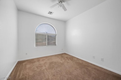 Spare room featuring carpet floors, ceiling fan, a