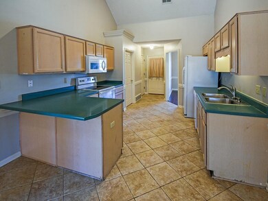 The kitchen has light cabinets and like-new applia
