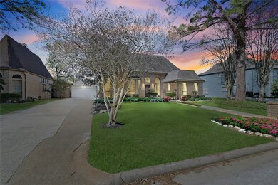 Twilight view highlighting the home’s spacious lot, extended driveway, and welcoming curb appeal.